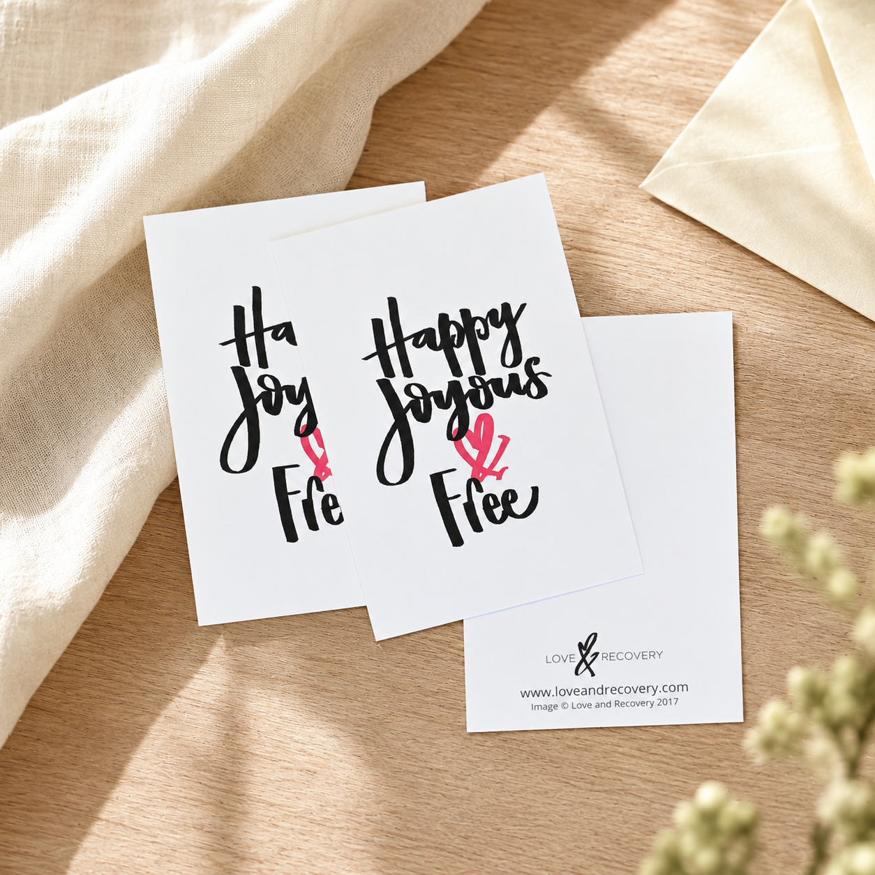White encouragement cards with Happy Joyous & Free on the front; blank on the back.
