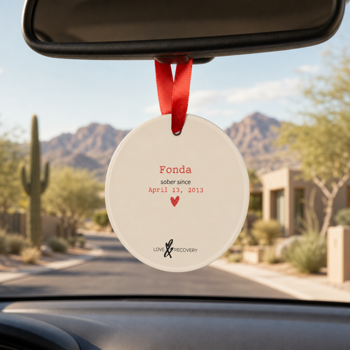 Personalized sobriety ornament hanging from a car rearview mirror as a daily recovery milestone reminder