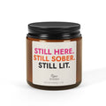 Personalized sobriety candle in a 4 oz amber jar with 'Still Here. Still Sober. Still Lit.' label, custom name and sobriety date