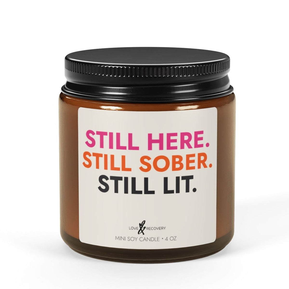 Still Here. Still Sober. Still Lit. sobriety candle in a 4 oz amber jar, Love & Recovery, front view