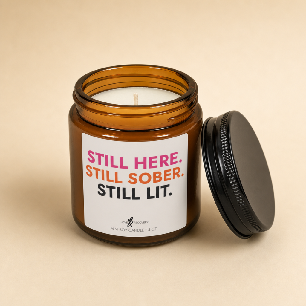 Sobriety candle, 4 oz jar with lid off on a warm tan background, showing the wick and soy wax